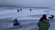 Wędkarze uciekają na stały ląd, przed falą, która łamie lód